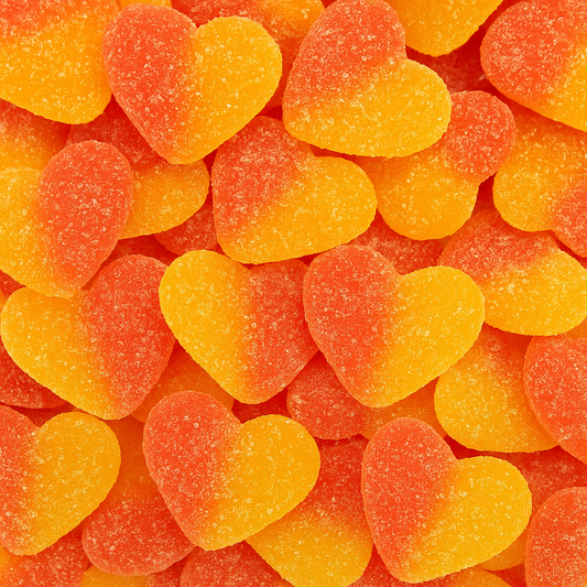 “Close-up of peach-flavoured heart-shaped gummy lollies coated in sugar crystals, showing orange and yellow tones on a white background.”