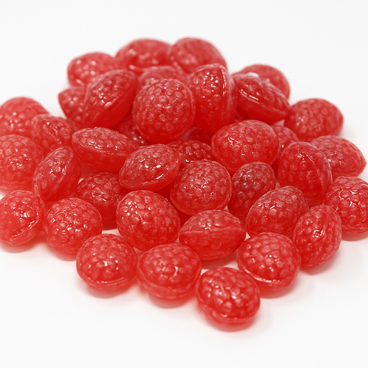 “Close-up of glossy red raspberry drop candies with a bumpy texture, arranged in a small pile on a clean white background.”