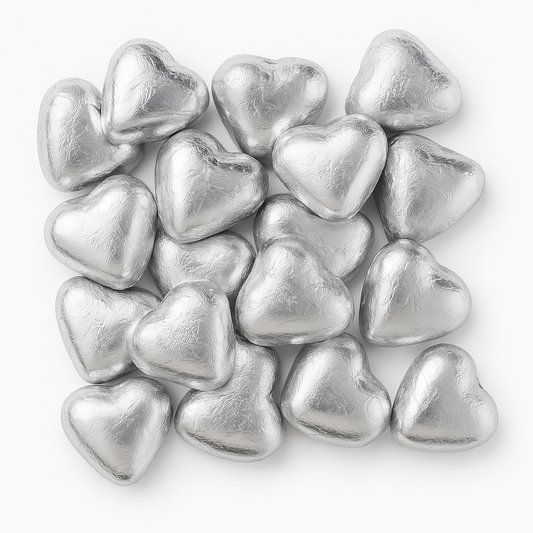 Silver foil-wrapped chocolate hearts arranged on a white background — elegant candies ideal for weddings, events, and gifts.