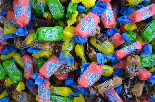 Assorted Lolliland Milkshake Chews in colourful wrappers, showing pink, brown, and cream tones representing classic milkshake flavours like strawberry, chocolate, and vanilla.