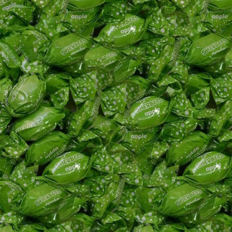 Close-up of green candy wraps with 'apple' branding.
