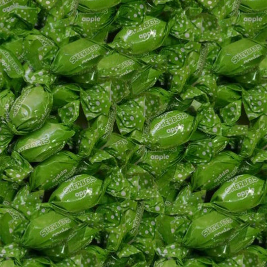 Close-up of green candy wraps with 'apple' branding.