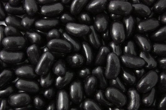 “Close-up image of glossy black jelly beans with a smooth coating and chewy texture, displayed on a white background.”
