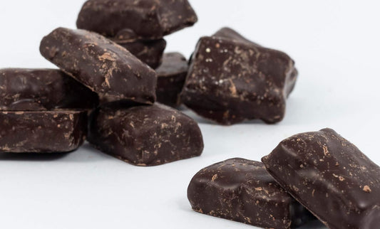 “Close-up of chocolate-coated cherry bites with rich glossy chocolate and chewy cherry centres, displayed on a clean white background.”