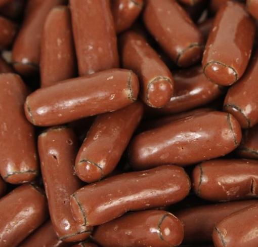Chocolate-coated licorice bullets arranged closely together on a white background, showing glossy milk chocolate coating.