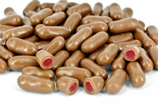“Close-up of chocolate raspberry bullets — chewy raspberry centres coated in smooth milk chocolate, displayed on a clean white background.”