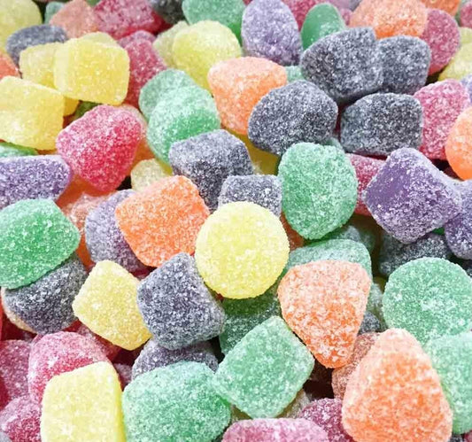 Colourful sugar-coated hard jubes in assorted flavours, including red, green, yellow, orange, and purple, displayed on a white background.