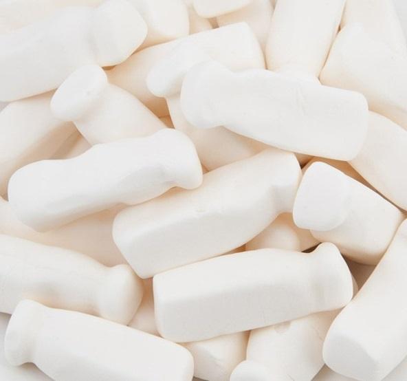 Soft, white milk bottle-shaped lollies displayed on a white background, showing smooth and chewy foam texture.