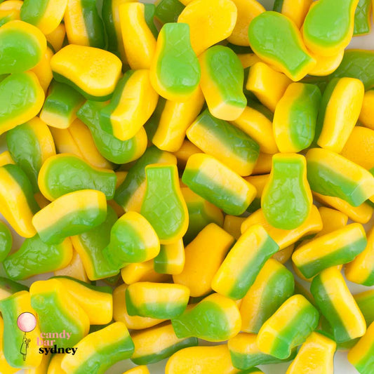 “Close-up image of pineapple-shaped gummy lollies in bright yellow and green colours, arranged together on a clean surface.”