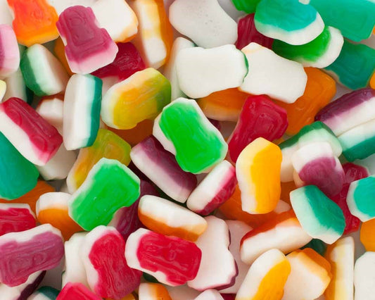 “Close-up image of colourful gummy racing car candies in shades of red, orange, yellow, green, and white, displayed together on a bright background.”