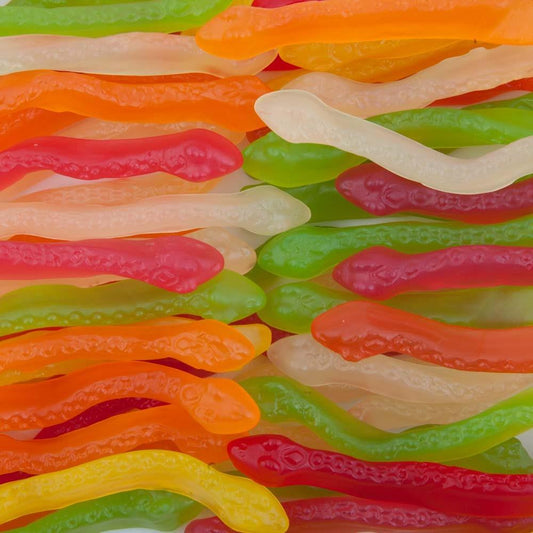 Colourful gummy snakes in red, green, orange, and yellow, displayed on a white background showing their soft and chewy texture.