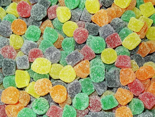 Assorted soft, sugar-coated fruit jubes in bright colours including red, green, yellow, orange, and purple, displayed on a white background.