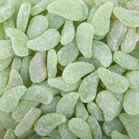 Soft green mint leaf-shaped lollies coated in sugar, displayed on a white background showing their chewy and glossy texture.