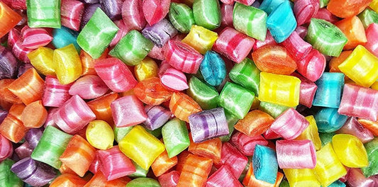 close up image of colourful shiny tiny tots sweets, yellow orange blue pink, bursting with colour and flavour