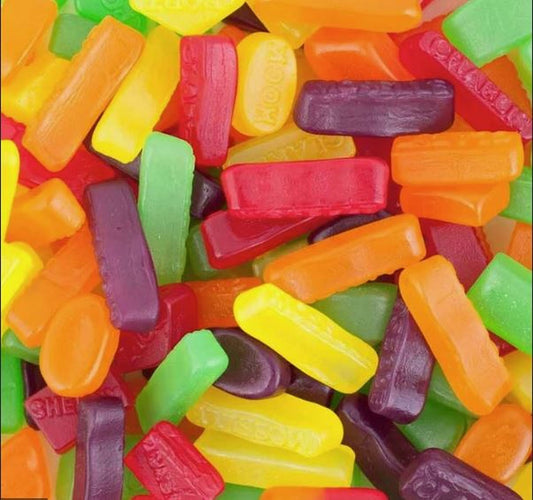 “Close-up of colourful chewy wine gums in assorted shapes and vibrant colours like red, orange, yellow, green, and purple.”