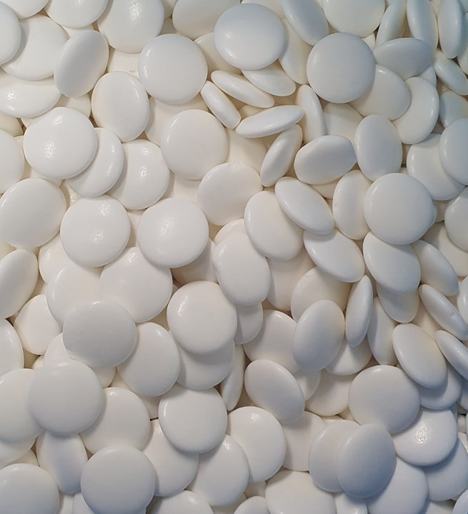 “Close-up of glossy white extra strong peppermint candies with a smooth shiny surface, neatly arranged on a clean white background.”