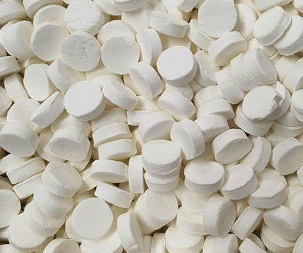 “Close-up of white powdered extra strong peppermint candies with a matte finish, arranged neatly on a clean white background.”