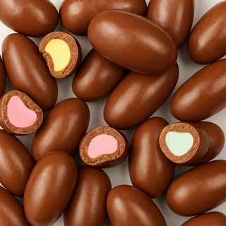 Chocolate-coated candy pieces with colourful chewy centres, showing glossy brown coating and a bite revealing the inside, displayed on a white background.