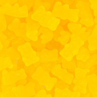 “Close-up of bright yellow honey bear gummy candies with a glossy, soft texture on a white background.”