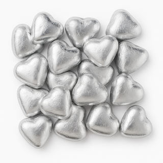 Silver foil-wrapped chocolate hearts arranged on a white background — elegant candies ideal for weddings, events, and gifts.