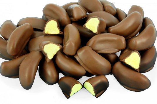 “Close-up of milk chocolate-coated banana lollies with bright yellow banana-flavoured centres, displayed on a clean white background.”