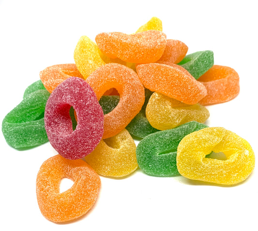 “Close-up of colourful fruit-flavoured gummy rings coated in sugar crystals, displayed on a white background.”