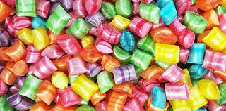 close up image of colourful shiny tiny tots sweets, yellow orange blue pink, bursting with colour and flavour