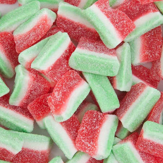 “Close-up of colourful watermelon slice lollies coated in a layer of sugar crystals, featuring red and green gummy candy pieces on a white background.”
